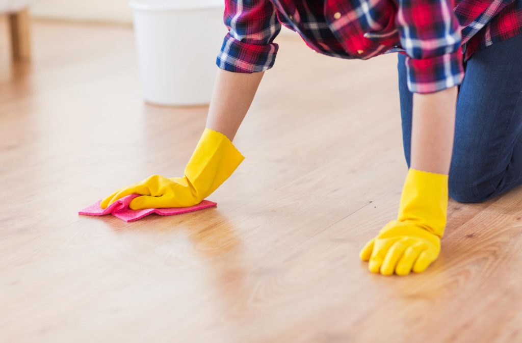 lady kneeling down to wipe the floor