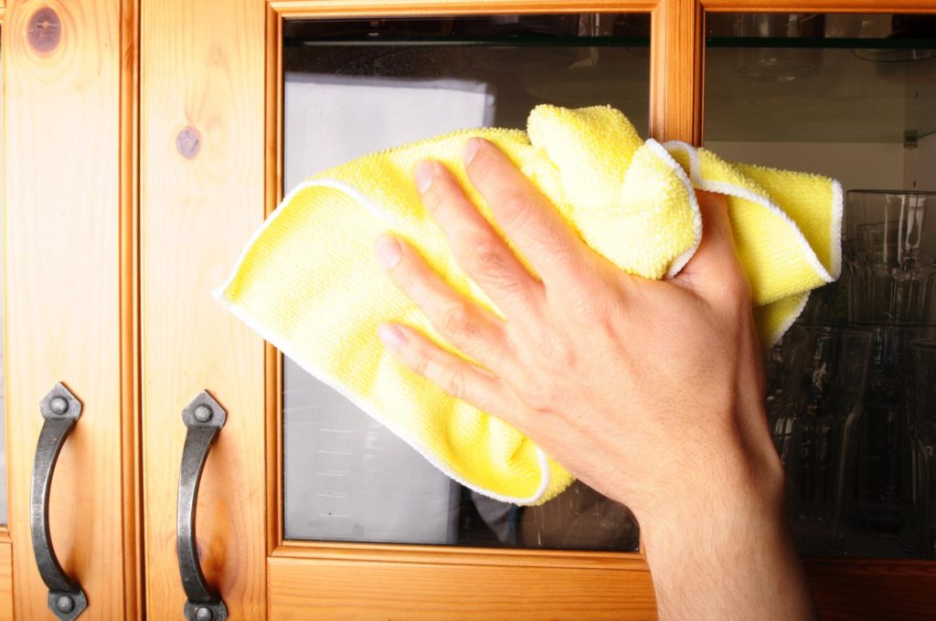 someone wiping the glass of the cabinet