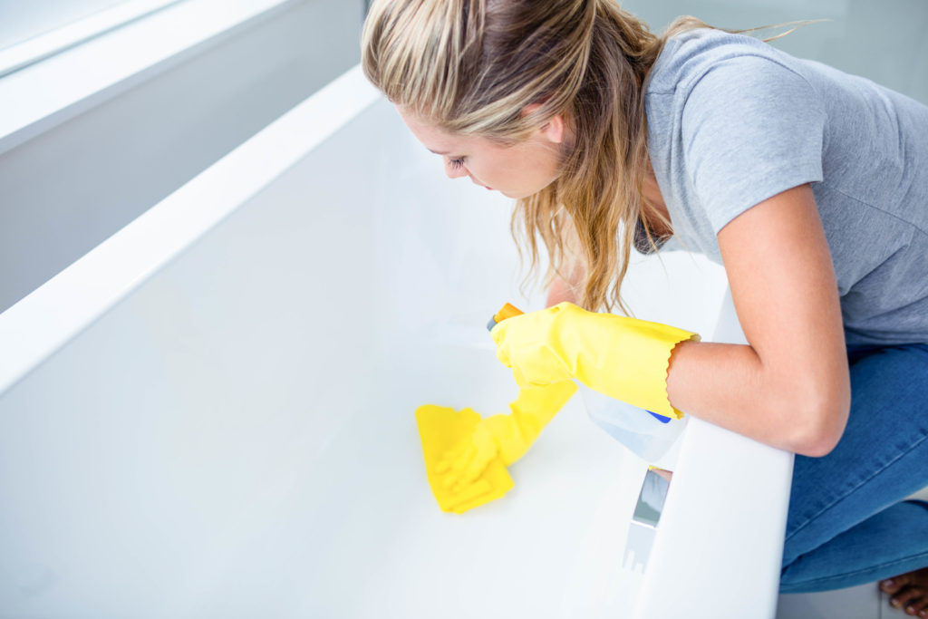 a lady cleaning the bathtub