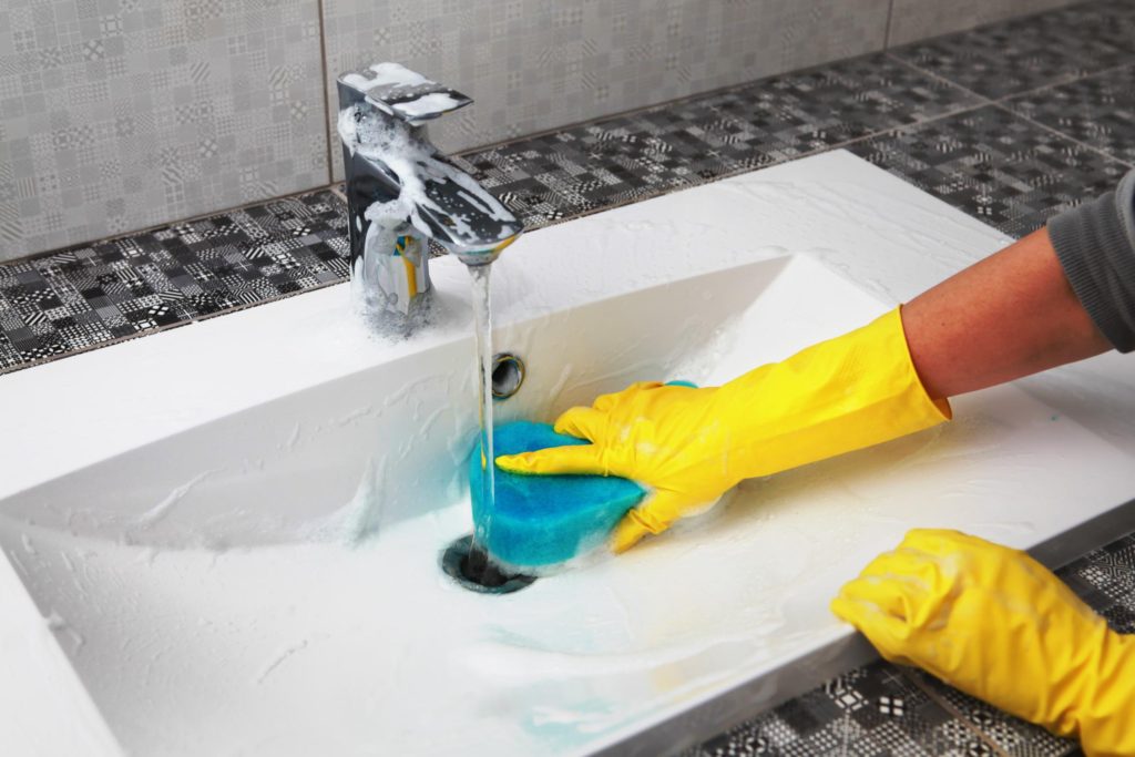 someone cleaning the bathroom sink